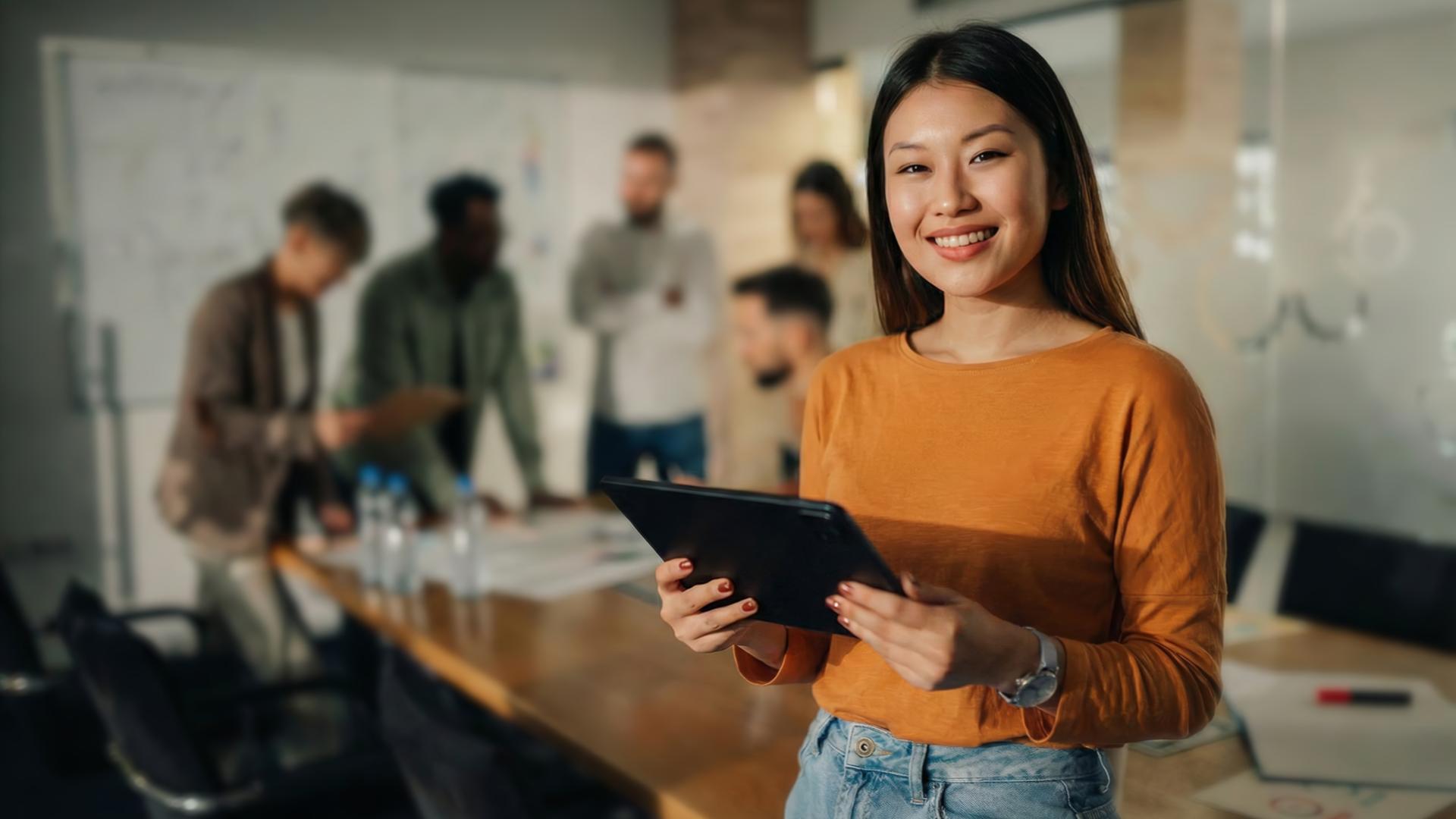 Mesa de reunião com três tablets exibindo comparativo de plataformas de engajamento de equipes